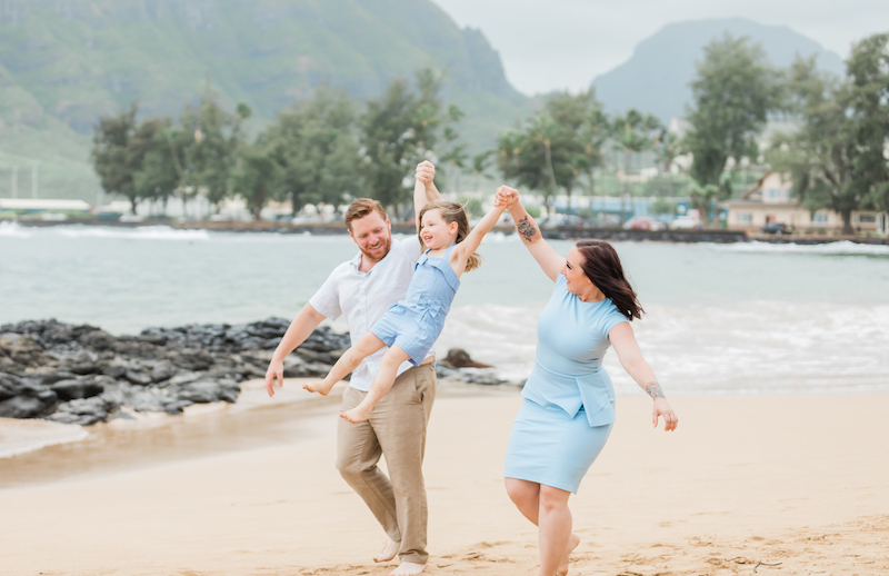 Parents playing with their child on the beach