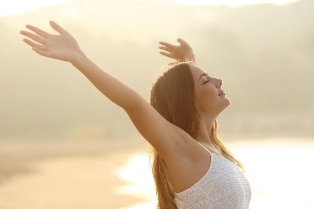 Young woman holding up her arms confidently