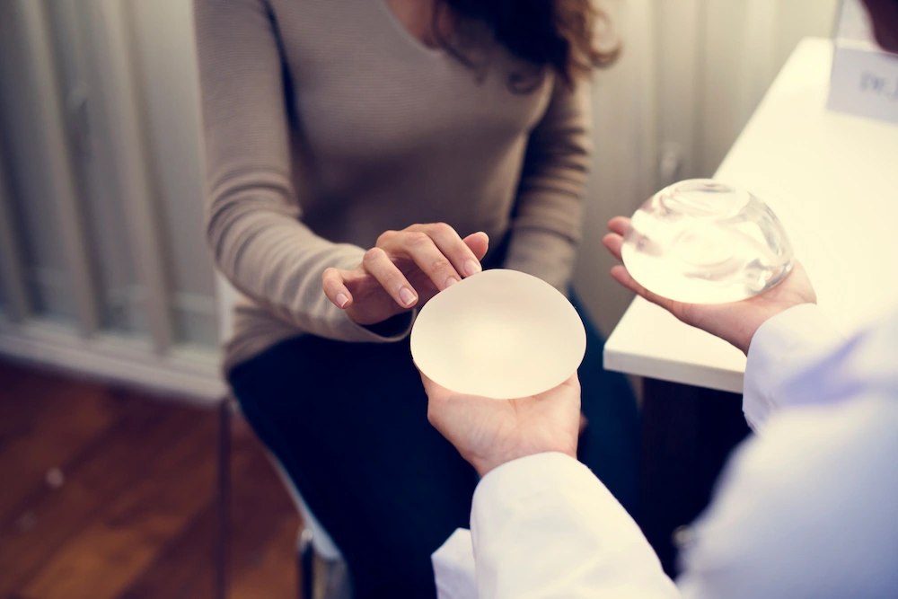 patient looking at breast implants during consultation